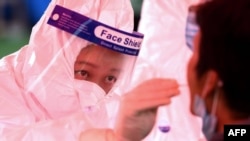 一位青岛医务人员正在给受试者做核酸检测。(资料图)