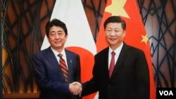 2017年11月11日习近平在越南与安倍会谈前笑容握手(日本首相官邸档案图片)