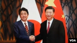 11月11日习近平在越南与安倍会谈前笑容握手(日本首相官邸档案图片)