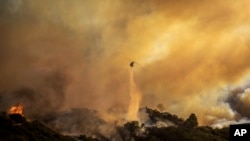 直升机尝试扑灭蔓延中的洛杉矶帕利塞德社区大火。(美联社:2025年1月7日)