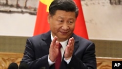 在人民大会堂,在中共党旗旁边,中共总书记习近平在与记者见面时鼓掌 (2017年10月25日)