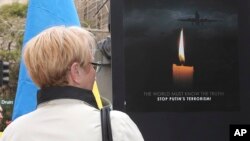 Một người phụ nữ cầm biểu ngữ phản đối Putin ở Sydney, Australia, sau khi xảy ra vụ rớt máy bay của Malaysia Airlines.