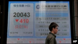 一位男士走过香港一家银行外显示香港股指的电子屏幕。(2016年1月11日)