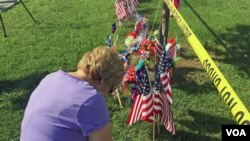 一名妇女在美国田纳西州查塔努加枪击现场附近哀悼丧生的四名海军陆战队队员。一名海军士官后来伤重不治而死。(美国之音贝恩拍摄)