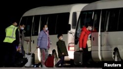 Công dân Úc đến từ thành phố Vũ Hán của Trung Quốc, tâm dịch Covid, lên xe bus tại phi trường trên đảo Christmas, Australia, ngày 6/2/2020.