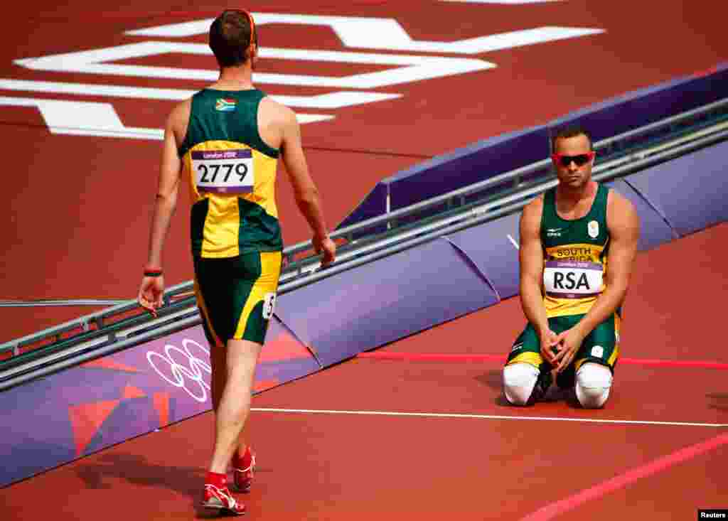 Hai tay điền kinh Oscar Pistorius (phải) và Willem de Beer của Nam Phi, sau khi không hoàn tất cuộc đua 400 mét tiếp sức 4 người nam. 9/8/2012. REUTERS/David Gray