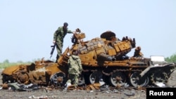Representatives of the separatist self-proclaimed Donetsk People's Republic inspect a burnt tank during a joint operation to search for the remains of killed soldiers at the city's airport in Donetsk, Ukraine, May 22, 2015. Officials and the military repr