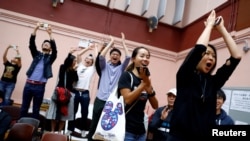 香港选民在他们支持的一名民主派候选人在区议会选举中获胜后鼓掌欢呼。(2019年11月25日)