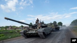 在靠近俄乌边界的乌克兰苏梅州,从俄罗斯境内返回的乌克兰军人坐在坦克顶上。(2024年8月15日)