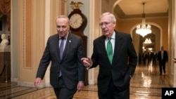 美国参议院多数党领袖麦康奈尔(右)和参议院少数党领袖查克·舒默(D-New York)2018年2月7日在华盛顿的国会大厦就预算协议合作后走进会议厅。