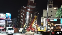 台湾花莲,救援人员站在一栋因地震而严重倾斜的大楼前。(2024年4月3日)