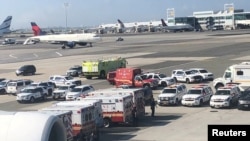 一架来自迪拜的班机发生乘客染病事件,警车和救护车出现在纽约肯尼迪机场跑道。