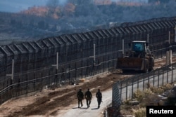 以色列士兵行走在叙利亚和被占领的戈兰高地之间的停火线附近。(2024 年12月9日)