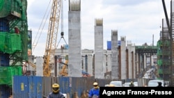 资料照:2021年7月12日,驾驶者行驶在内罗毕蒙巴萨公路上,旁边是内罗毕高速公路正在施工的工地,该高速公路由中国路桥公司承建(法新社)。