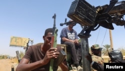 资料照片:一名苏丹武装部队成员手持武器坐在一辆军车上。(2024年3月9日)