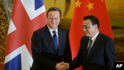 英国首相卡梅伦(左)和中国总理李克强12月2日在人民大会堂举行联合新闻发布会时握手。
