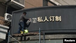 Một công nhân đang tháo các ký tự tiếng Hoa của chữ ‘Nam Hàn’ trên bảng hiệu của một cửa hàng ở Thượng Hải, Trung Quốc, ngày 15/3/2017