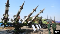 2024年12月19日越南军方官员在河内举行的越南 2024 年国际防务博览会上查看S-125-2TM防空导弹发射器和弹药。