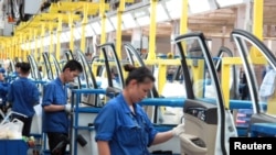 资料图:在中国广西壮族自治区柳州市的通用五菱汽车工,员工在一条生产线上工作。(路透社2016年6月19日)