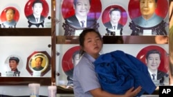 北京一个礼品摊上,习近平和毛泽东的纪念盘并列(2014年6月4日)