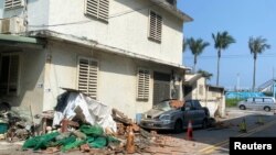 台湾4月3日强震后,一辆停在路边的汽车被掉落的砖块砸中受损。