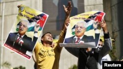 Người dân Palestine giơ cao những tấm áp phích có hình Tổng thống Mahmoud Abbas để ủng hộ những nỗ lực của ông trong việc bảo đảm một sự nâng cấp ngoại giao tại LHQ, 29/11/2012.