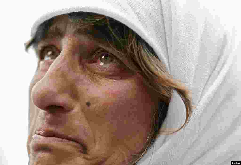 Một phụ nữ xúc động khi xem màn hình khổng lồ chiếu cảnh ra đi của Ðức Giáo Hoàng ở Vatican, ngày 28/2/2013.