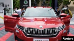 戴着口罩的参观者在上海举行的一个汽车销售会上查看斯柯达牌的汽车。(资料照: 2020年5月5日)