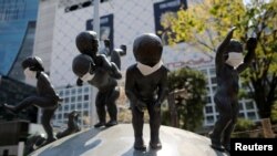 日本政府为抗疫宣布了东京的紧急状态后街头塑像被戴上口罩。(2020年4月8日)