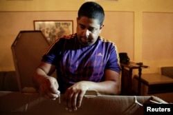 A man assembles a cardboard coffin at a mortuary in Valencia, in the state of Carabobo, Venezuela, Aug. 25, 2016.