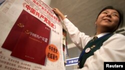Tư liệu - Một người dân cầm trên tay tờ quảng cáo về cuốn sách lịch sử Trung Quốc, ngày 02 tháng 10 năm 2002.