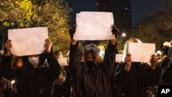 抗议者于2022年11月27日在北京拿着白纸高呼口号,反对政府的清零政策。(美联社资料照)