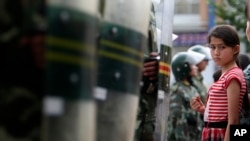 新疆首府乌鲁木齐一名维族少女被拦中国防爆武警设置的警戒线外。-资料照