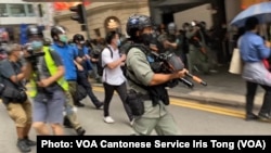 大批香港防暴警察2020年5月27日中午在中环毕打街一带多次施放胡椒球弹,驱散反对中国国歌法立法的示威群众。 (美国之音汤惠芸拍摄)
