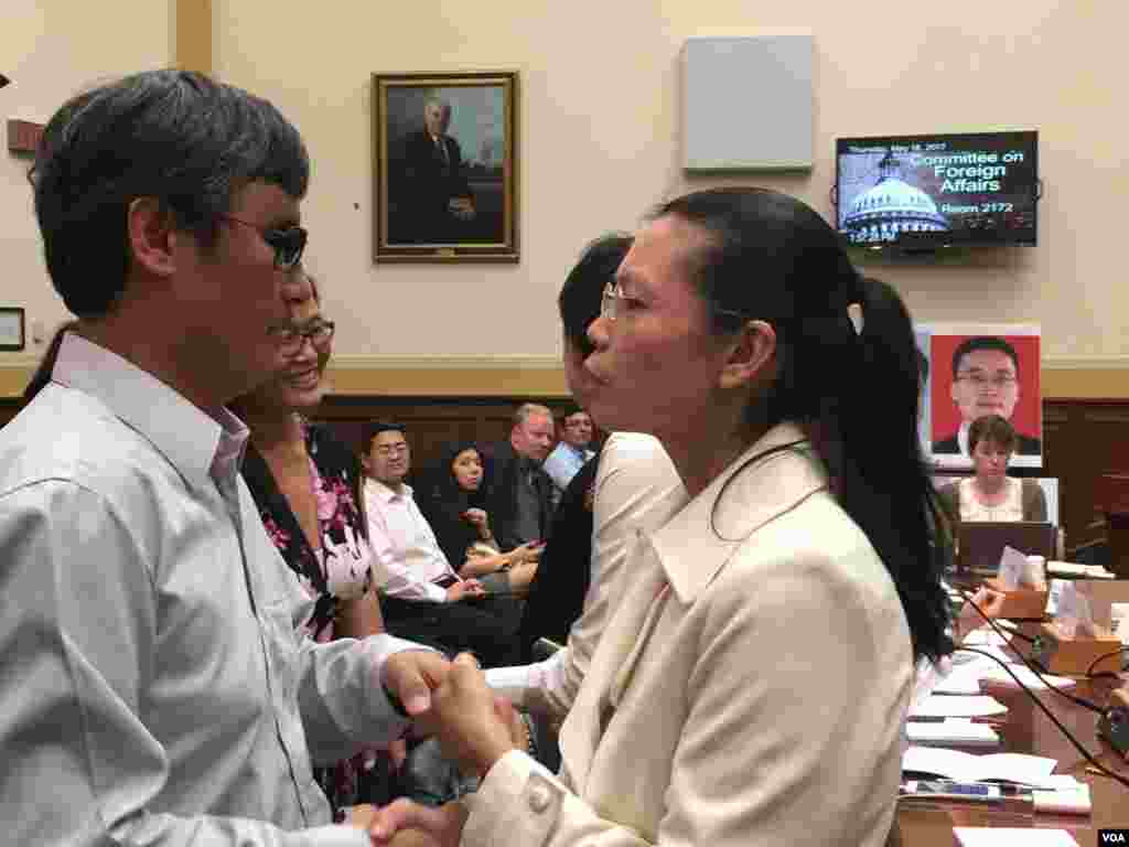 中国人权活动人士陈光诚和被中国政府关押的台湾人权工作者李明哲的妻子李净瑜在美国国会听证会上握手 (2017年5月18日,美国之音钟辰芳拍摄)