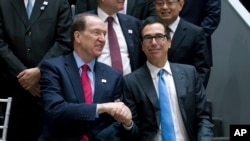 2019年4月12日星期五,在华盛顿举行的世界银行/国际货币基金组织春季会议上,美国财政部长姆努钦和世界银行行长马尔帕斯握手。