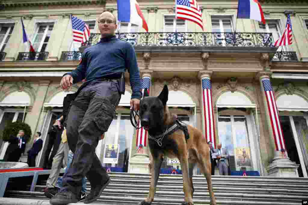 在美国独立241周年之前,在美国驻法国巴黎大使馆的住宅楼前面,法国警察带着警犬巡逻。