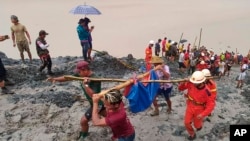 缅甸北部克钦邦帕敢玉石矿区发生山体滑坡,救援人员抬着一具遇难者遗体。(2020年7月2日)