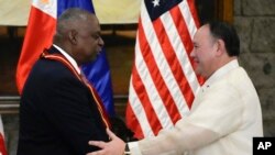 Menteri Pertahanan Nasional Filipina Gilberto C. Teodoro, Jr.,(kanan), menganugerahkan Medali Prestasi Luar Biasa kepada Menteri Pertahanan Amerika Lloyd J. Austin III di markas militer Camp Aguinaldo di Quezon City, Filipina, 18 November 2024. (Aaron Favila/AP)
