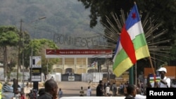 资料照片:中非共和国首都班吉的总统府附近一名男子手持中非旗帜。