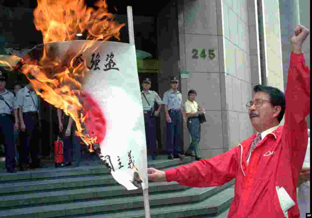 Một người biểu tình đốt cờ Nhật bên ngoài sứ quán không chính thức của Nhật tại Đài Bắc, 5/9/2012 để phản đối Nhật đòi chủ quyền ở dãy đảo Điếu Ngư.