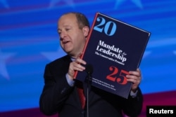 科罗拉多州州长贾里德·波利斯(Jared Polis)2024年8月21 日在美国伊利诺伊州芝加哥举行的民主党全国代表大会 (DNC) 的第三天手捧一本“2025 计划”。(路透社)