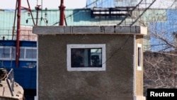 一名朝鲜士兵在鸭绿江边朝鲜的新义州前沿哨所用望远镜观察对岸中国境内,中国丹东市与新义州隔江相望