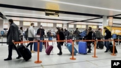 图为伦敦南部一个机场中的乘客。由于英国出现了新冠病毒的新病毒株,美国要求英国飞美航班的乘客必须要有新冠检测阴性的证明。