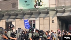 10月27日,一名女士在抗议现场与港警对话(美国之音李逸华拍摄)