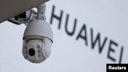 在北京一家商场外的华为标志旁安装了一个监控摄像头。(2019年1月29日)