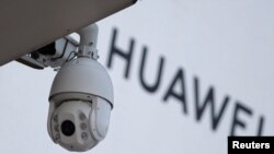 在北京一家商场外的华为标志旁安装了一个监控摄像头。资料照（2019年1月29日）