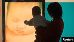 在广州妇产医院,一位女性抱着孩子的背影