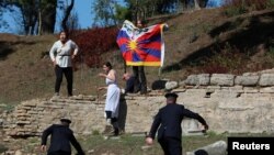 手举自由西藏旗帜的抗议者在奥林匹克圣火火炬点燃仪式上抗议,希腊警察前去拦截拘捕。(2021年10月18日)