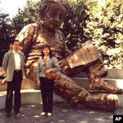 李淑娴和方励之1986年在华盛顿的美国科学院大门前的爱因斯坦雕像前合影。爱因斯坦手上的一张纸写有三个公式(从下到上):E=mc2;光电效应;广义相对论方程。注意:广义相对论方程中没有宇宙常数项